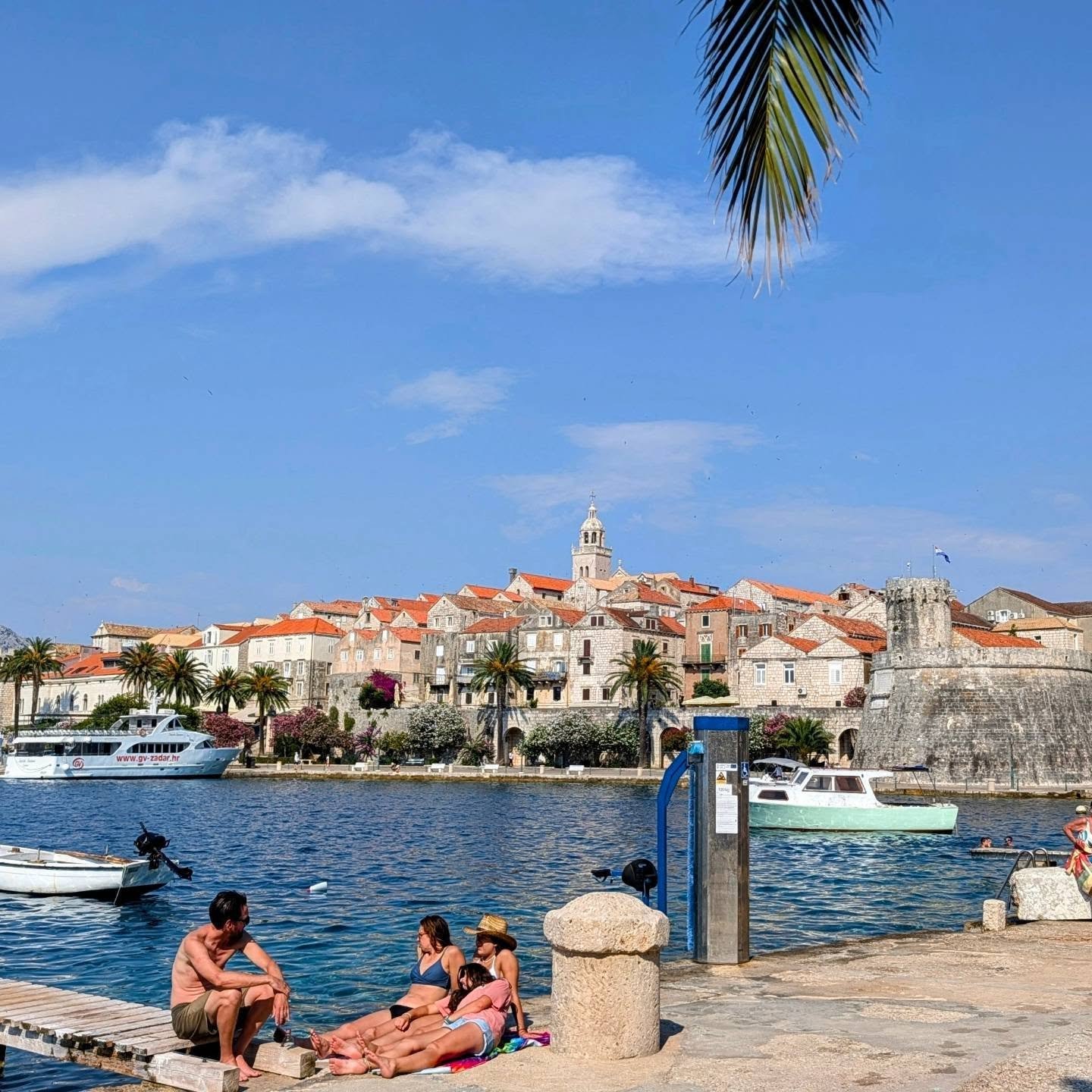 Korčula harbour and old town seen across the waterfront on a sunny day